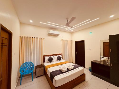 Un dormitorio con una cama y una silla azul. en Rizz Villa, en Trivandrum
