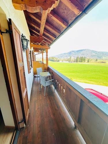 a porch with a table and a view of a field at Ferienwohnung Beim Raffner in Ruhpolding