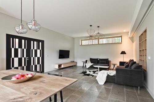 a living room with a table and a couch at Ami Residence Forest in Didžiasalis