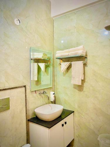 a bathroom with a sink and a mirror and towels at Hotel Tulsi Grand inn in Vrindāvan
