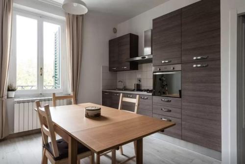 a kitchen with a wooden table and a dining room at Appartamento Ai Giardini in Empoli