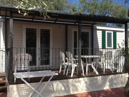 a screened in deck with chairs and a table at Camping Edy in Diano Marina