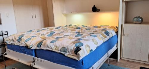a bed with a blanket on it in a room at Mayenzett 25, komplett renoviert, vis-à-vis Klinik & Thermalbad in Leukerbad