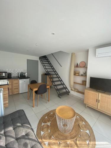 un salon avec un escalier et une table dans l'établissement Appartement climatisée Alès, à Saint-Privat-des-Vieux