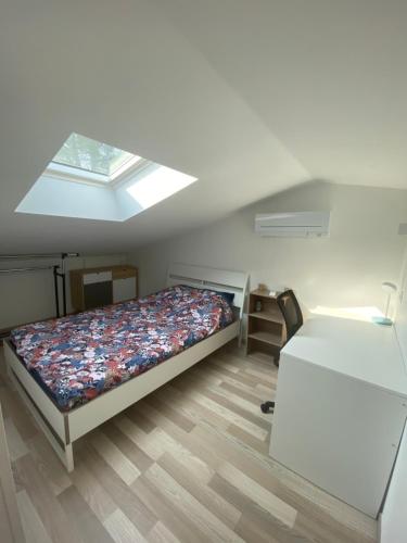 - une petite chambre avec un lit et une lucarne dans l'établissement Appartement climatisée Alès, à Saint-Privat-des-Vieux