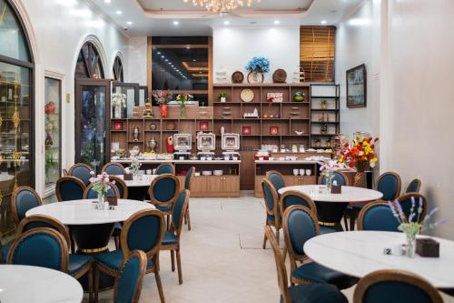 un ristorante con tavoli, sedie e un bancone di Roza Palace Cat Ba a Cat Ba