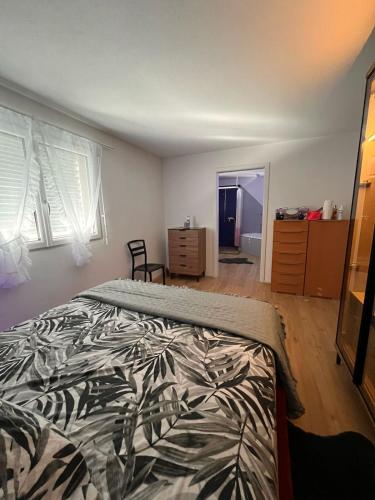 a bedroom with a bed and a dresser and windows at Ferienwohnung, 4 Personen in Lausen