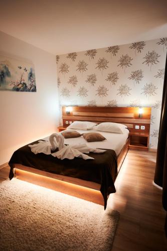 a bedroom with a large bed with a wooden headboard at Poiana Bucovat in Gura Humorului