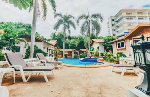 a patio with chairs and a swimming pool at Kotchaporn garden in Pattaya South