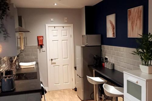 a kitchen with a white door and a refrigerator at Spacious and homely city centre studio in Coventry
