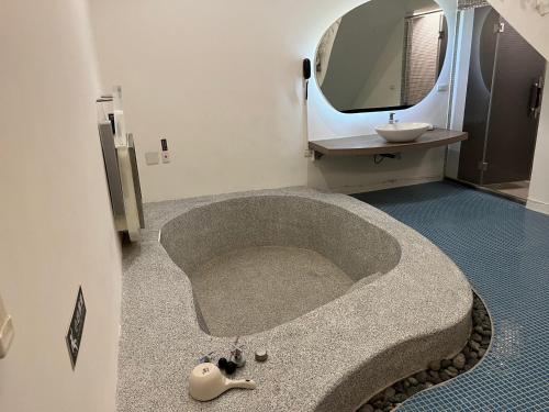 a bathroom with a sink and a bath tub at Ya Nold Hot Spring Hotel in Jiaoxi
