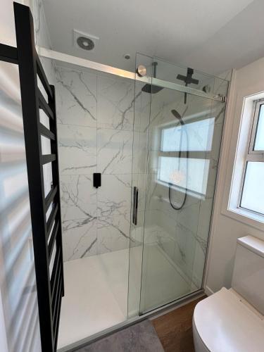 a shower with a glass door in a bathroom at Luxury stay in Tutukaka in Whangarei