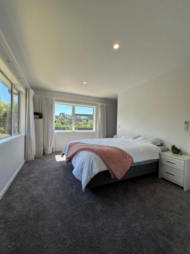 a bedroom with a large bed and a large window at Luxury stay in Tutukaka in Whangarei