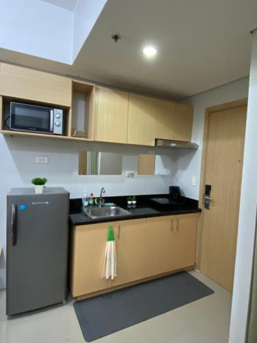 a small kitchen with a sink and a microwave at Theodore Alfonzo rental in Manila