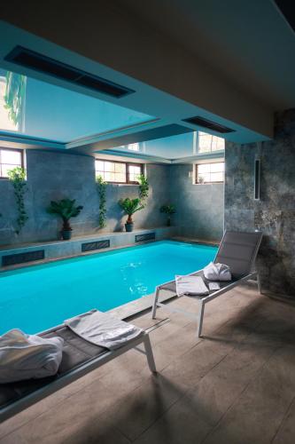 a swimming pool with two lounge chairs next to it at Poiana Bucovat in Gura Humorului