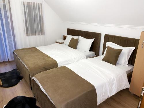 two beds in a hotel room with white and brown at Chalet Kujta in Peje