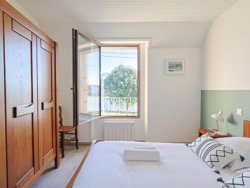 une chambre avec un grand lit et une grande fenêtre dans l'établissement Maison port de Perros-Guirec, à Perros-Guirec