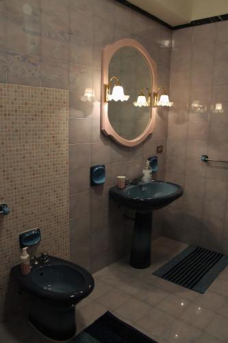 a bathroom with a toilet and a sink and a mirror at Palazzo Scavone in Palermo