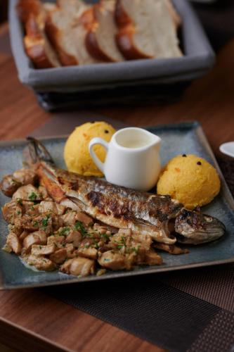 a plate of food with fish and potatoes on a table at Poiana Bucovat in Gura Humorului