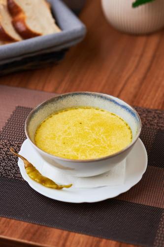 a bowl of soup on a plate on a table at Poiana Bucovat in Gura Humorului