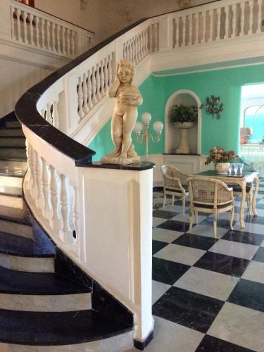 a statue of a child on a staircase in a house at Palazzo Scavone in Palermo