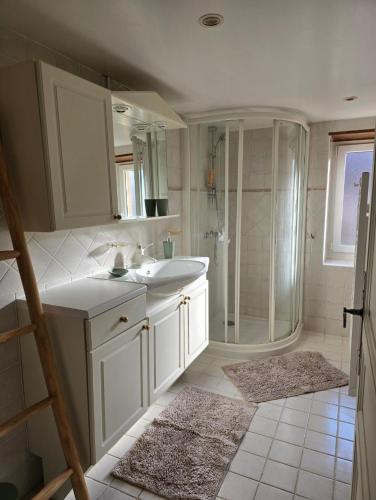 une salle de bain blanche avec un lavabo et une douche dans l'établissement La Maison De Jade, à Meyrals