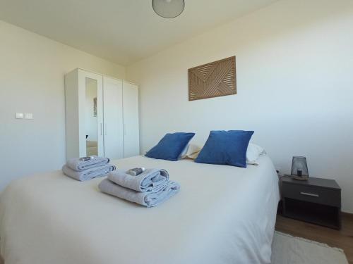 a bedroom with a white bed with towels on it at Appartement neuf, parking privé, 2 chambres in Bischheim