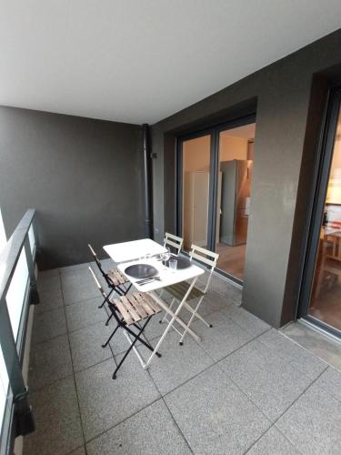 a room with a table and chairs in a room at Appartement neuf, parking privé, 2 chambres in Bischheim
