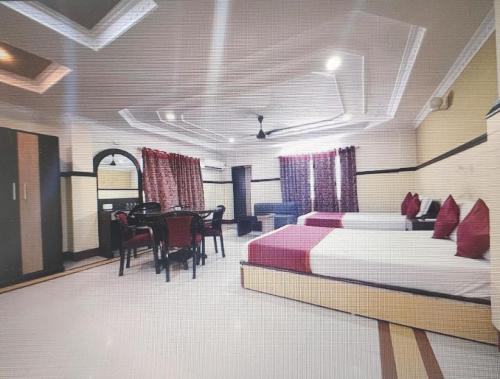 a bedroom with a bed and a dining room at Hotel Inn New Digha With Classic Swimming Pool in Digha