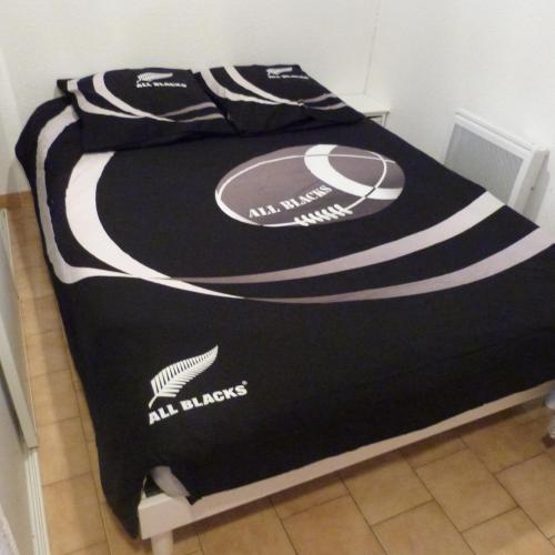 - un lit avec une couverture noire et blanche dans l'établissement Studio cabine dans résidence avec piscine, à Valras-Plage