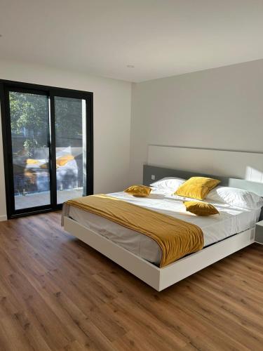 a bedroom with a large bed and a large window at Sisters Apartamento -200m2 centre ville in Ponte da Barca