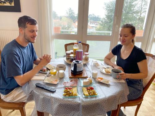 サン・セバスティアン・シュル・ロワールにあるBed and Breakfast Nantes au calme proche aéroport, gare et centre-villeの食べ物を食べる男女