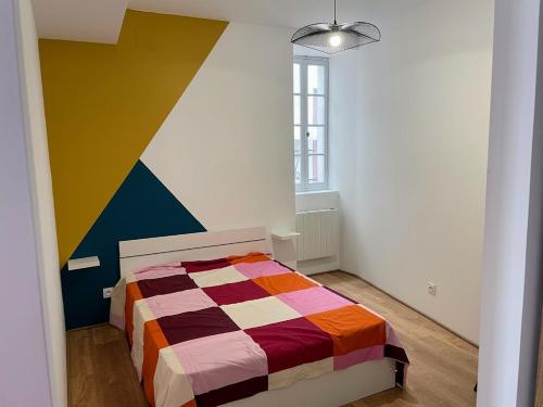 - une chambre avec un lit coloré dans l'établissement Le Coloré- T2 confortable avec vue sur Nérac, à Nérac