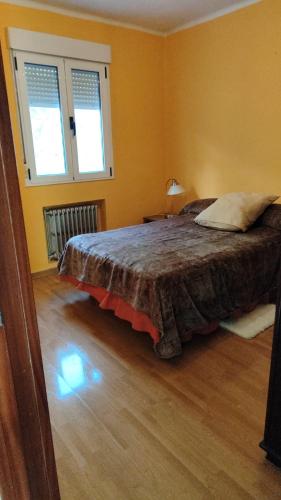 a bedroom with a bed and two windows at Asturias Montaña y Playa in La Vega
