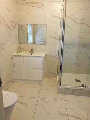 a bathroom with a shower and a sink at Greensborough Motel in Melbourne
