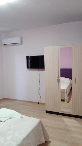 a bedroom with two beds and a television on the wall at Комплекс Тянкови къщи in Varshets