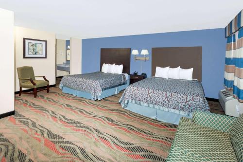スプリングフィールドにあるDays Inn by Wyndham Springfieldのベッド2台とソファがあるホテルの部屋