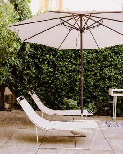 a chair and an umbrella on a patio at Maison Matilda - Luxury Rooms in Treviso