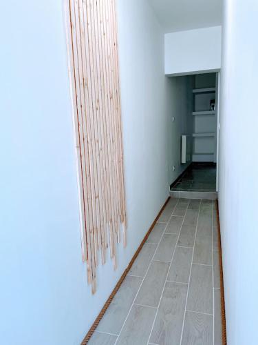 une pièce avec un couloir avec une cuisine avec une porte dans l'établissement Le Cosy - T2 avec petite cour dans centre historique de Nérac, à Nérac