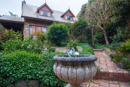 沃伯顿The Tolpuddle Cottage的房子前面有喷泉的花园