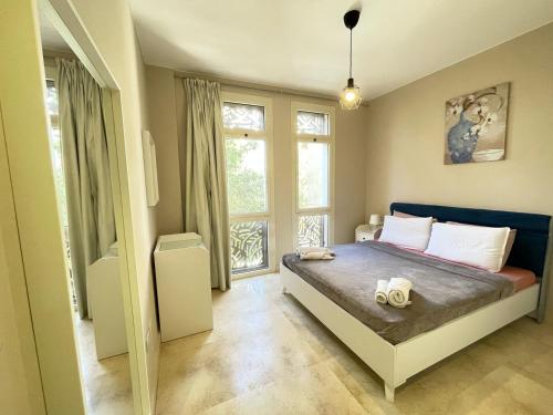 a bedroom with a bed and a large window at Cozy 1BD in Mangroovy El Gouna in Hurghada