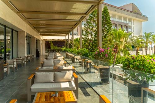 凯麦尔DoubleTree by Hilton Antalya-Kemer All-Inclusive Resort的庭院里一排长椅和桌子