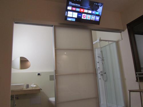 a bathroom with a toilet and a television on the wall at B&B Golfo Asinara Suite & Relax in Sorso