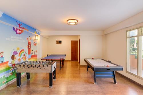two ping pong tables in a room with a mural at The Chumbi Mountain Retreat & Spa, A Club Mahindra Associate in Pelling