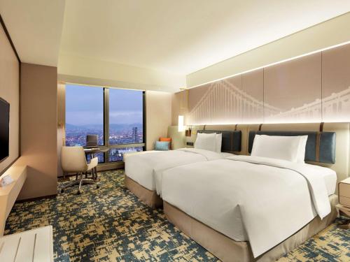 a hotel room with two beds and a television at Hilton Taipei Sinban in Taipei