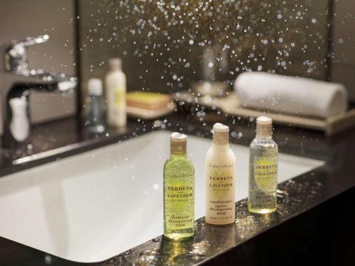 three bottles of soap sitting on a bathroom sink at Hilton Taipei Sinban in Taipei