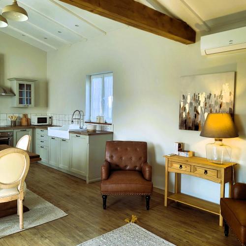 une cuisine avec une chaise et une table avec une lampe dans l'établissement Gîte Le petit Chemin, à Challignac