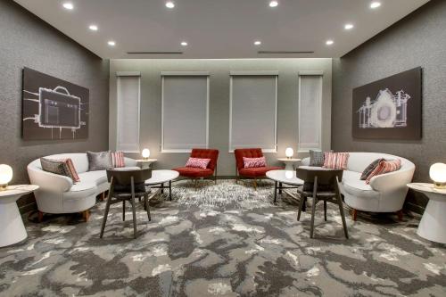 a waiting room with couches and tables and chairs at The Rose Chicago, Tapestry Collection By Hilton in Rosemont
