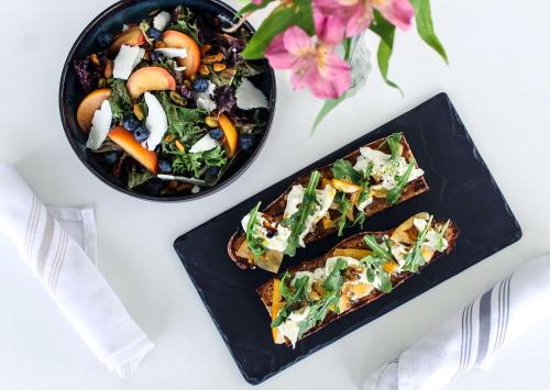 two black plates of food on a white table at The Rose Chicago, Tapestry Collection By Hilton in Rosemont
