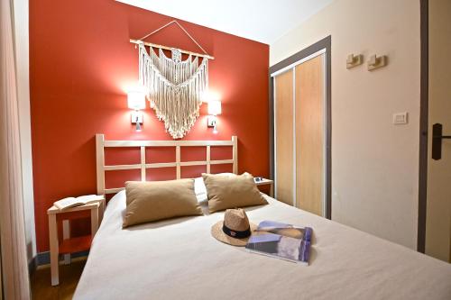une chambre avec un lit avec un chapeau dessus dans l'établissement Anémone, à Saint-Raphaël